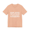 Front view of peach Bone Spurs anti-Trump military protest t-shirt with white text by Peach2Impeach