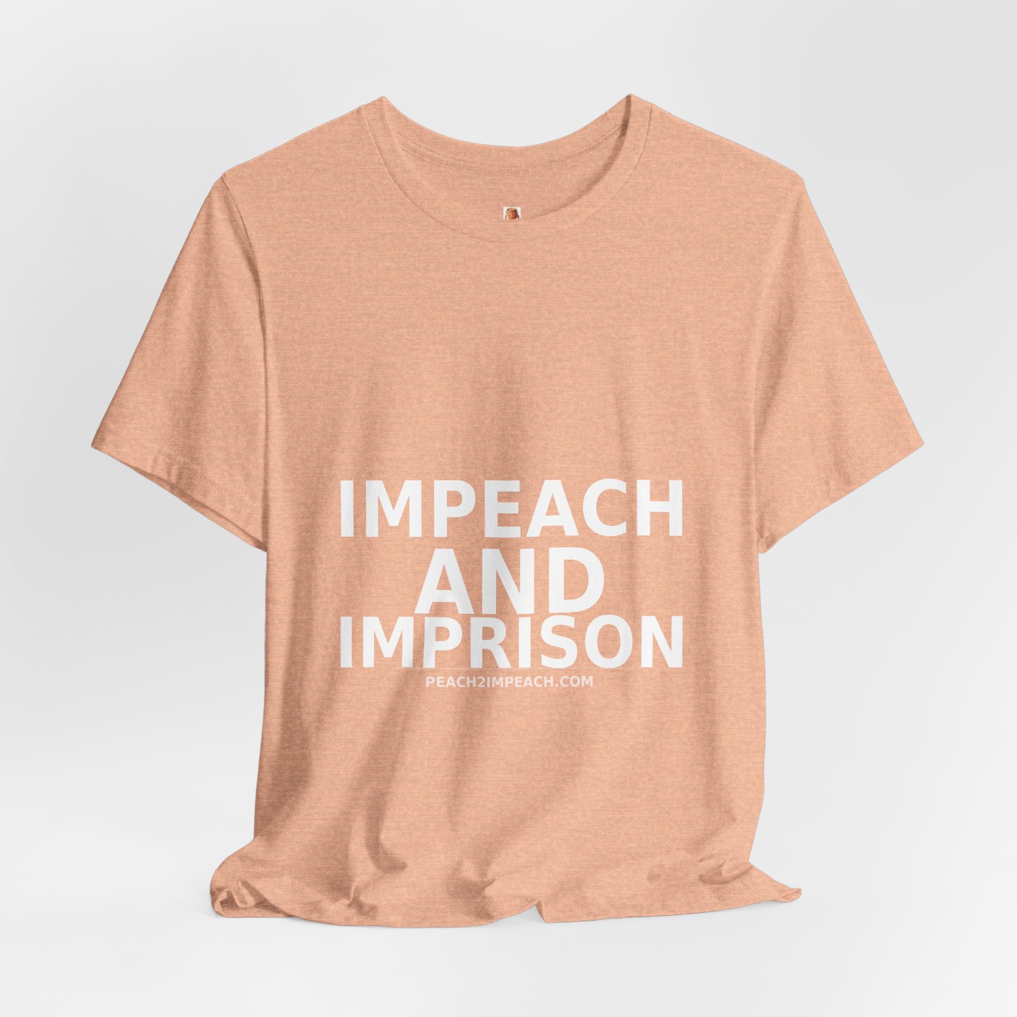 Impeach and Imprison heather peach tee flat lay showing soft cotton texture and DTG printed design